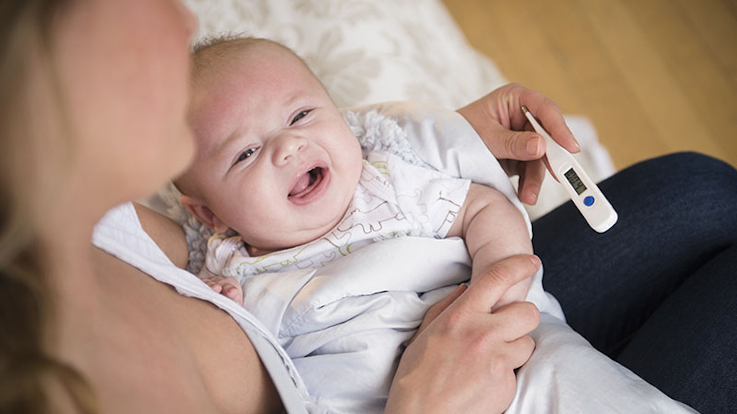Caucasian mother taking crying baby's temperature