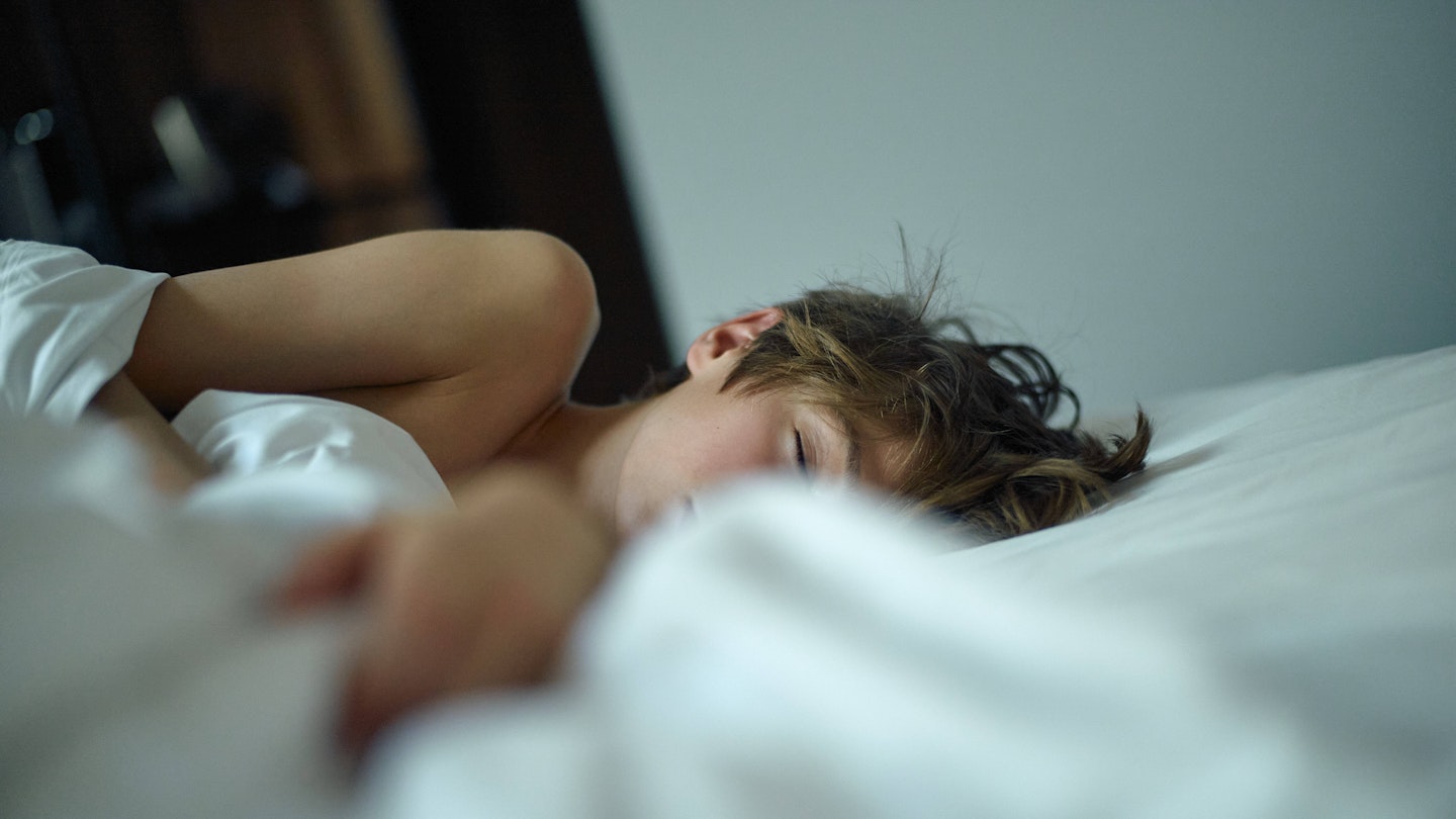 child sleeping peacefully in a white bed