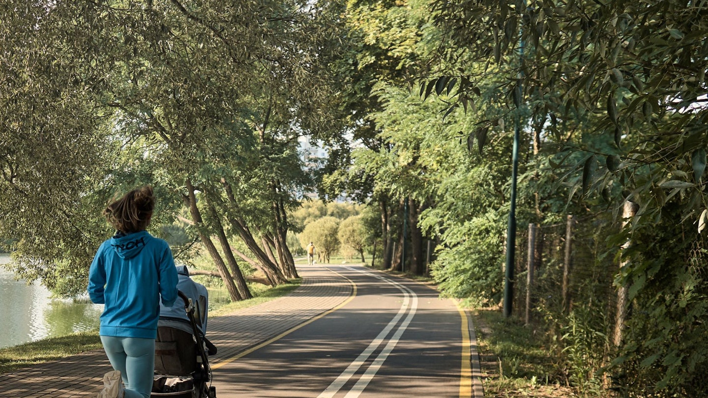 Mother Jogging While Pushing a Baby Stroller on the Road