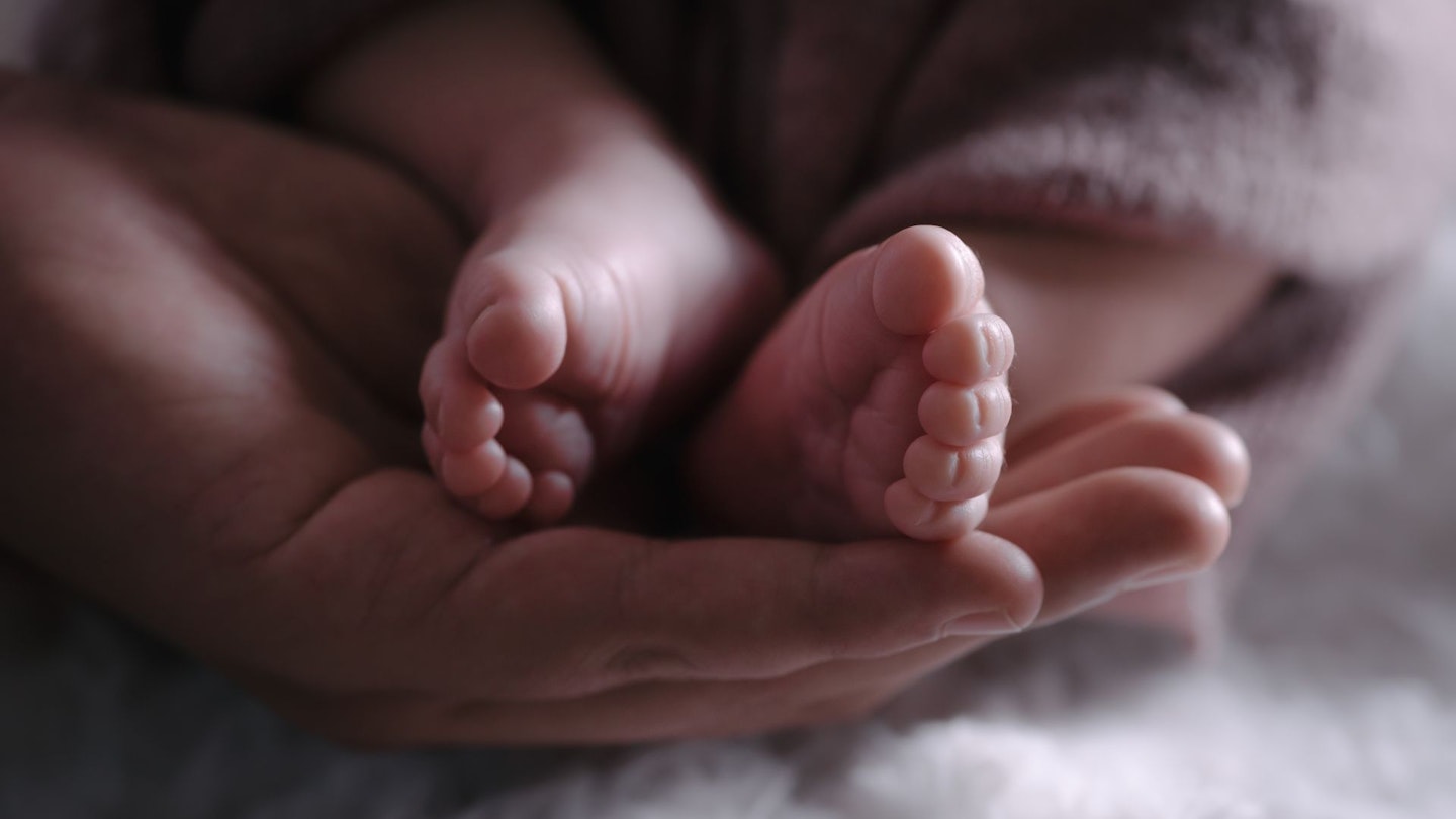 Mum holding baby's feet