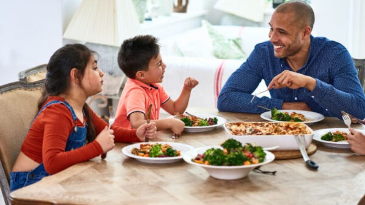 A dad sitting down to healthy family meals with his children